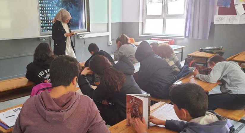 Öğretmenler öğrencilerle kitap okuyor